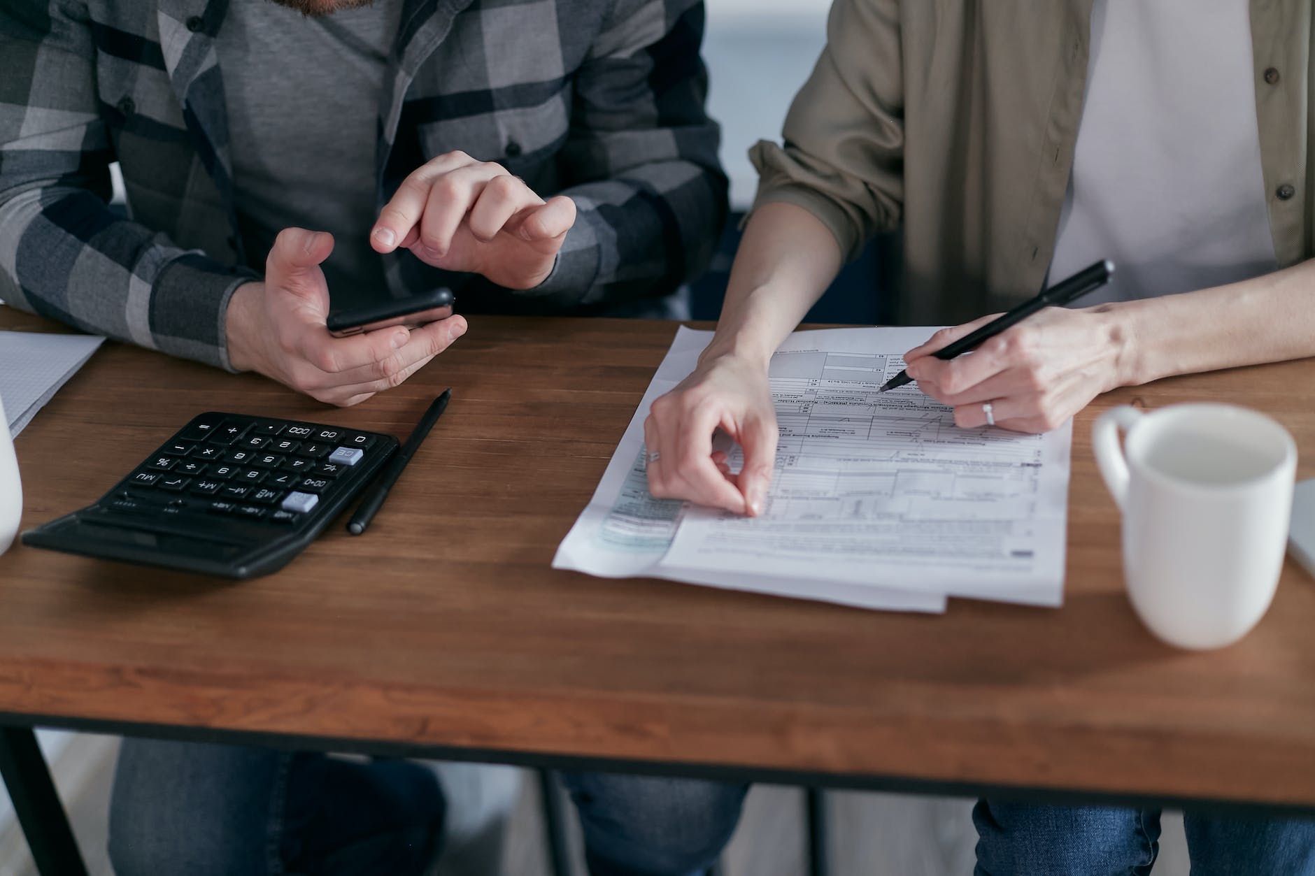 two people doing paperwork and computing taxes